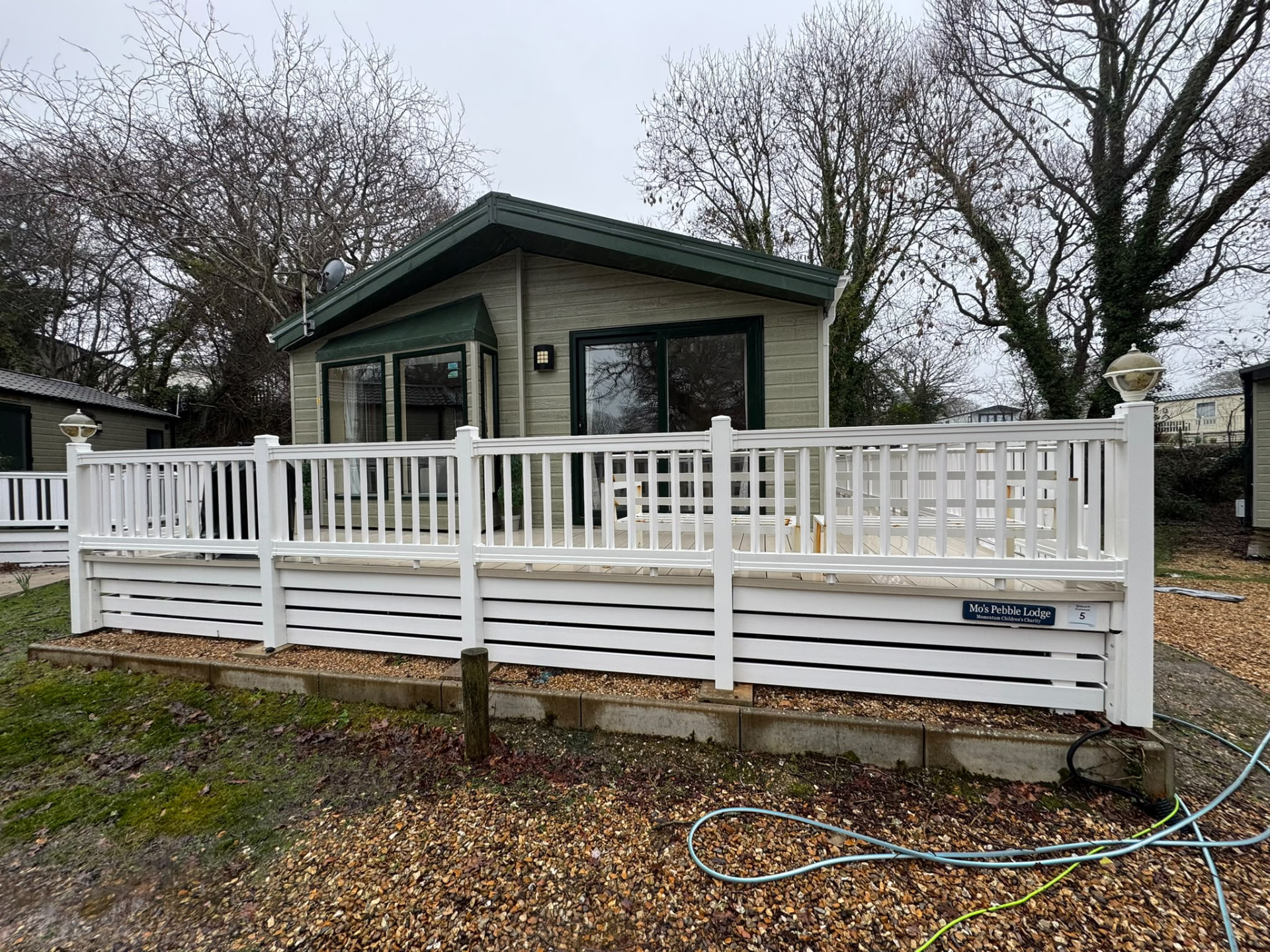 Static holiday lodge with clean cladding and white decking after exterior cleaning